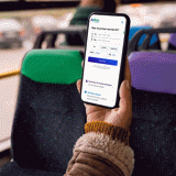 A passenger checks the RRReis app on a smartphone while on the bus