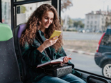 A passenger looks at her smartphone during a bus ride