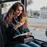 A passenger looks at her smartphone during a bus ride