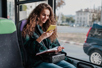 A passenger looks at her smartphone during a bus ride