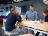 Jeroen, Dimitri and Kelly in discussion at the kitchen table