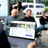 A traveler is browsing the RRReis website on a laptop at the station